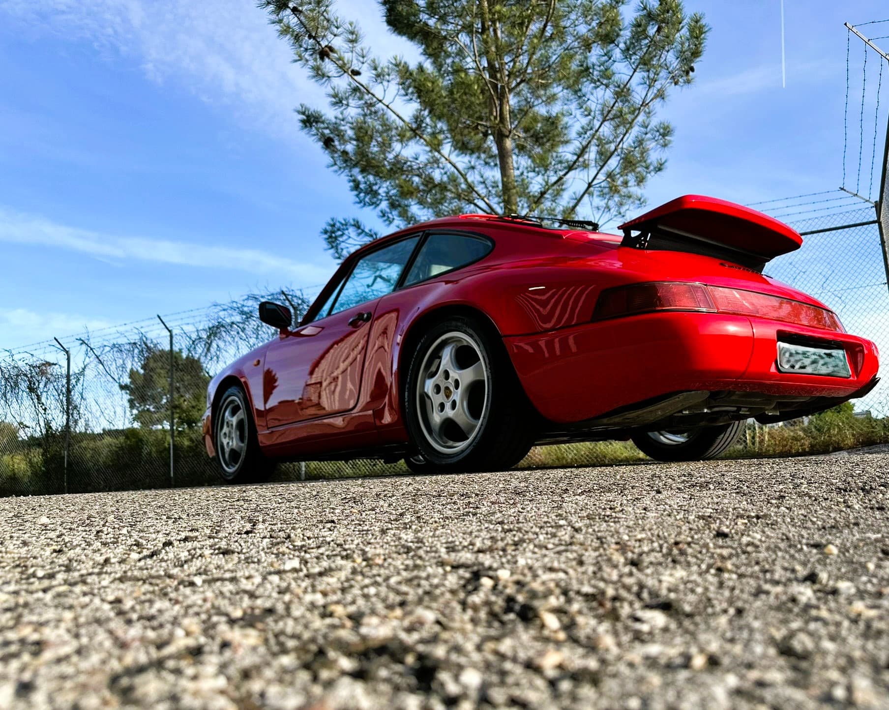 Red Porsche 964 with dramatic sunset reflections after full detail